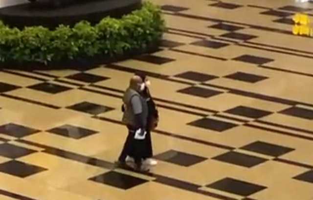 Gubernur Papua Lukas Enembe berjalan bersama perempuan di Changi Airport