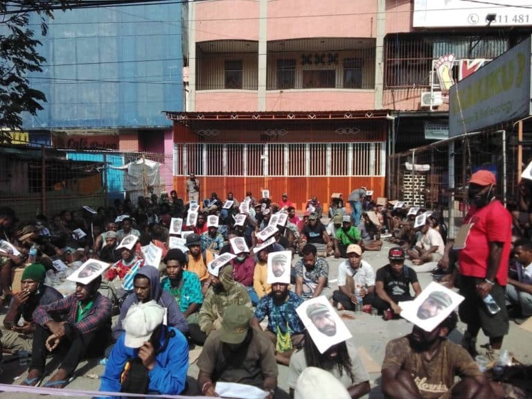 Para simpatisan dan aktivis Petisi Rakyat Papua berunjuk rasa di seberang gedung Pengadilan Negeri Jayapura